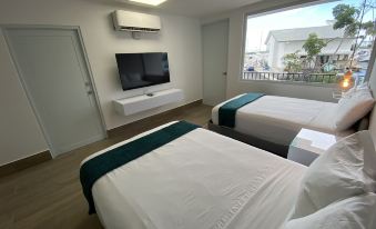 a hotel room with two beds , a tv on the wall , and a window overlooking the city at Marina de Salinas