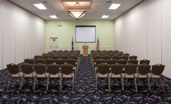 a conference room with rows of chairs and a projector screen , ready for a meeting at Ramada Plaza by Wyndham Sheridan Hotel & Convention Center