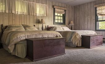 a cozy bedroom with two beds , one on the left and one on the right side of the room at Sylvan Falls Mill B&B