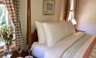 a large bed with white pillows and a plaid blanket is shown in a bedroom at Spring Hill Inn
