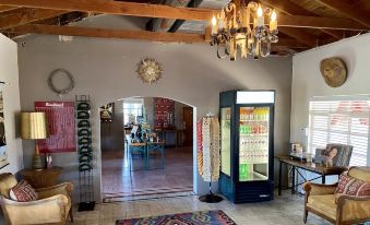 a room with a wooden ceiling , a chandelier hanging from the ceiling , and various items on shelves at Antelope Lodge