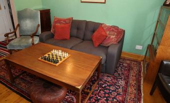 a cozy living room with a couch , a coffee table , and a chess board on it at Acorns Guest House