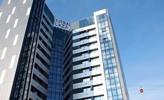 "a tall , modern building with a large glass window and the words "" city plaza "" written on it" at Central Plaza Hotel