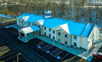 an aerial view of a blue and white hotel with multiple cars parked in front at Cobblestone Inn & Suites - Brookville