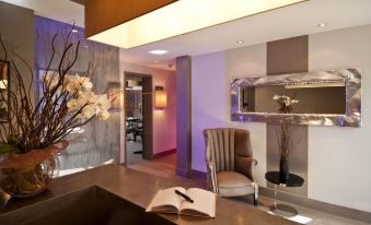 a hotel lobby with a marble reception desk , a chair , and a book on the desk at The Hide London