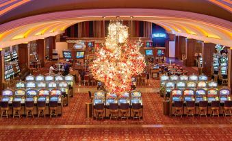 a large , well - lit room with multiple gaming machines and a christmas tree decoration hanging from the ceiling at Blue Chip Casino Hotel and Spa