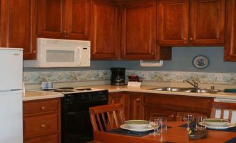 a kitchen with wooden cabinets , a black stove , and a dining table with chairs at Scandinavian Lodge