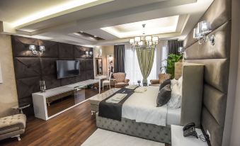 a luxurious hotel room with a king - sized bed , a flat - screen tv mounted on the wall , and a dining table at Hotel Mirror Skopje