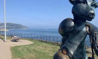 a statue of a bull on a pedestal , with a view of the ocean in the background at Horse & Hound