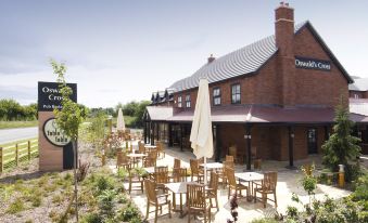 an outdoor dining area at a restaurant , with tables and chairs arranged for guests to enjoy their meals at Oswestry