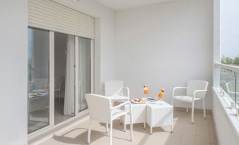 a white table with two chairs and a vase of oranges is set up in an outdoor patio at Nautilus