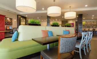 a dining area with multiple chairs and tables , creating a comfortable seating arrangement for guests at Home2 Suites by Hilton Portland