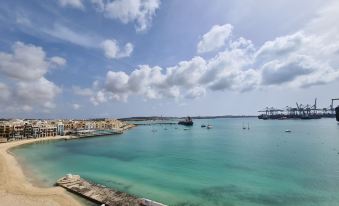 a body of water with boats docked at a marina , surrounded by buildings on the waterfront at Water's Edge Hotel