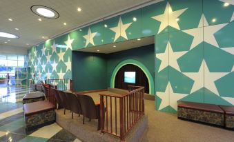 a conference room with a large star - themed wall and brown chairs , under a blue archway at Disney's All-Star Movies Resort