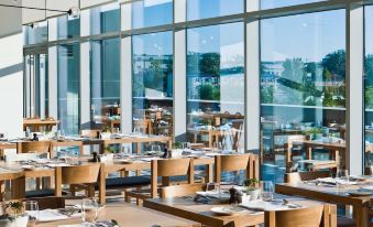 The dining room of the restaurant features large windows and tables that are arranged in a way that they face each other at EAST Beijing