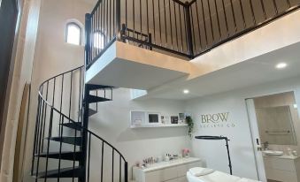 a modern living space with a spiral staircase , white furniture , and a chandelier hanging from the ceiling at Jodha Bai Retreat