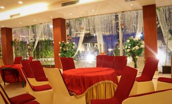 a dining room with a table covered in a red tablecloth , surrounded by chairs , and a view of a fountain in the background at The Retreat