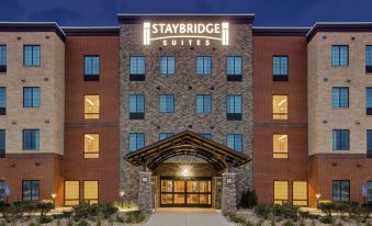 an exterior view of a large hotel building , featuring a large parking lot in the background at Staybridge Suites Benton Harbor - ST. Joseph