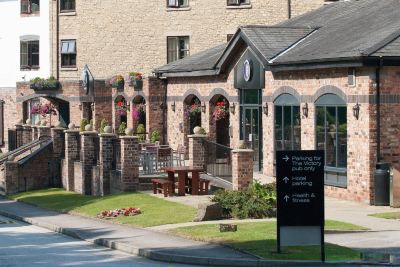 "a brick building with a sign that reads "" comfort inn "" on it , surrounded by a grassy area" at Village Hotel Liverpool