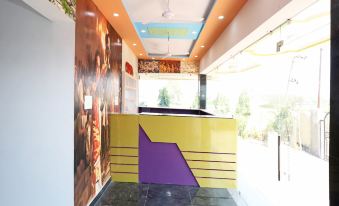 a modern office space with an orange and purple color scheme , featuring a reception area and a staircase at Collection O 27949 Hotel Kriti Green