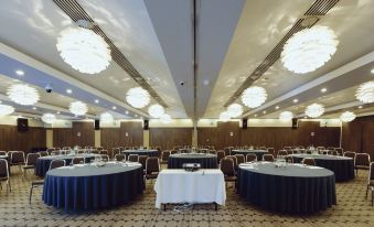 a large banquet hall with multiple round tables and chairs arranged for a formal event at Crowne Plaza London - Kingston