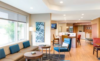 a modern living room with a couch , chairs , and coffee table is shown next to a kitchen area at TownePlace Suites Memphis Southaven