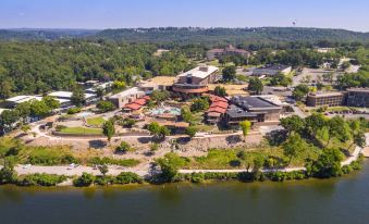 aerial view of a large building surrounded by trees and a body of water , with a lake in the background at Lodge of Four Seasons Golf Resort, Marina & Spa