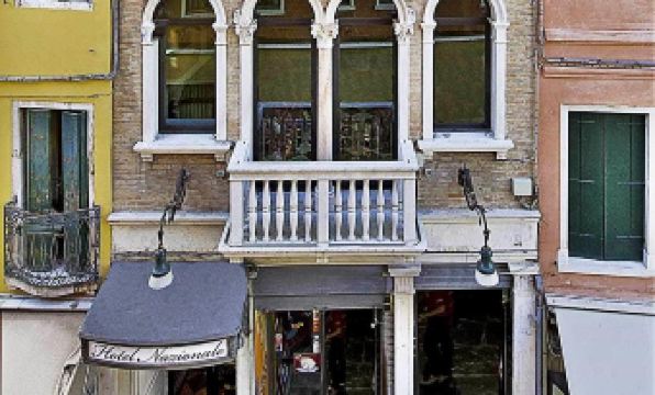 a colorful building with a white balcony and two floors , possibly in italy , situated on a street at Hotel Nazionale