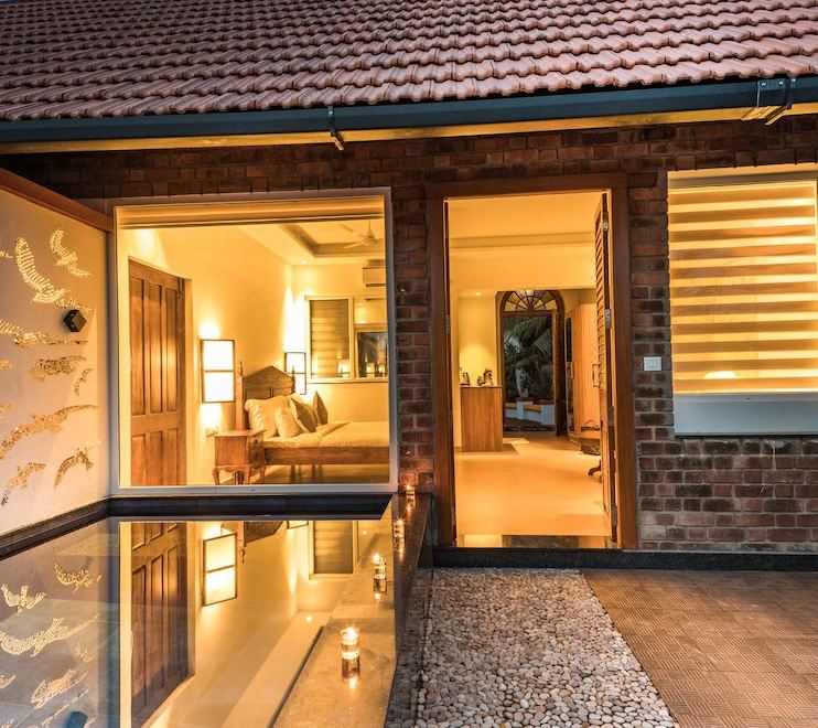 a modern house with a large glass door and a patio area , illuminated by lights at Over the Hill