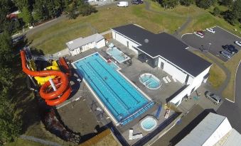 an aerial view of a large swimming pool with slides and a building in the background at Hildibrand Apartment Hotel