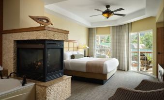 a modern hotel room with a large bed , a fireplace , and a view of the outdoors at Hyatt Vacation Club at the Welk, San Diego