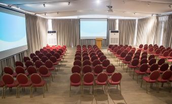 a conference room with rows of chairs arranged in a semicircle , and a projector screen mounted on the wall at Radisson Blu Anchorage Hotel