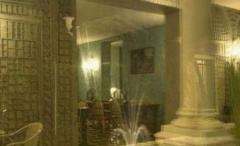 a large , ornate mirror reflects a fountain in the background , with a fountain in the foreground at La Maison Navarre