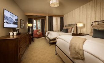 a hotel room with two beds , one on the left and one on the right side of the room at The Blake at Taos Ski Valley