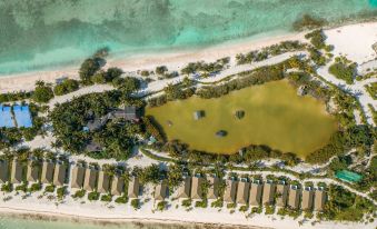 aerial view of a resort surrounded by water , with multiple buildings and palm trees in the background at South Palm Resort Maldives