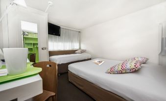 a hotel room with two beds , a desk , and a tv , decorated in white and brown colors at Campanile Marne la Vallee - Torcy
