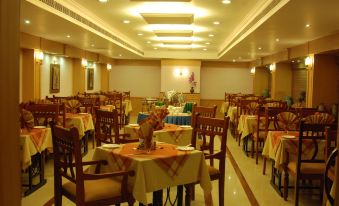 a large dining room with multiple tables and chairs arranged for a group of people to enjoy a meal together at Hotel Palace Inn