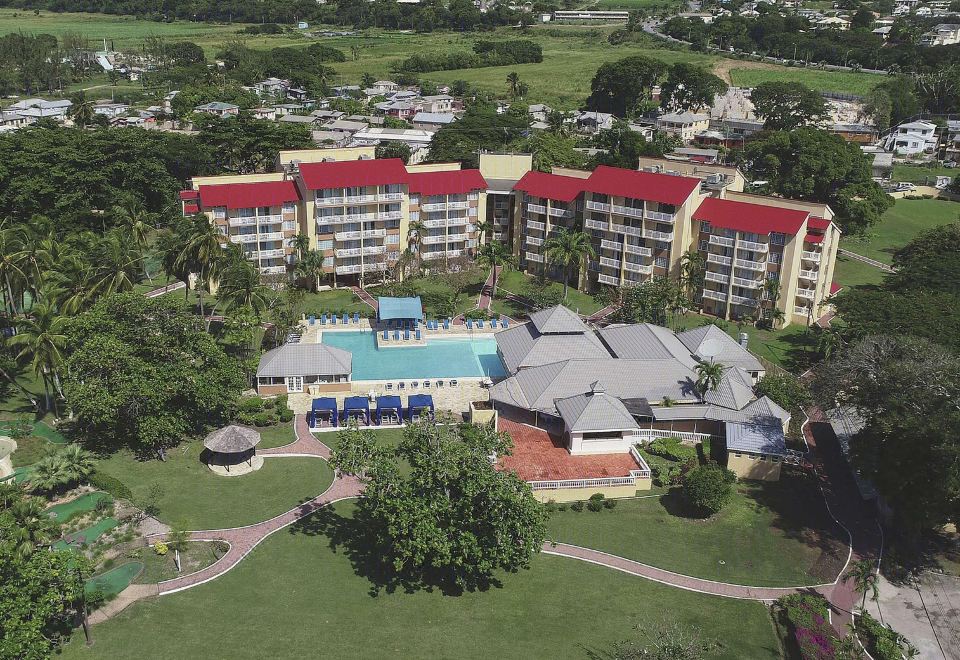 a bird 's eye view of a large resort with multiple buildings , swimming pools , and green spaces at Divi Southwinds Beach Resort