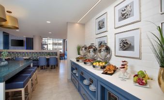 a dining room with a buffet table filled with various food items and utensils , including bowls , forks , knives , and spoons at Fenwick Shores, Tapestry Collection by Hilton