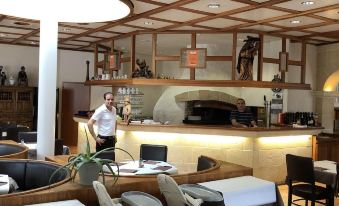 a woman is standing at a desk in a hotel lobby , wearing a suit and tie at Hotel du Soleil