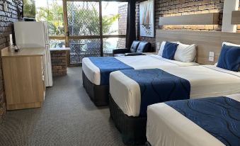 a hotel room with three beds , two of which are twin beds and one is a double bed at Logan City Motor Inn