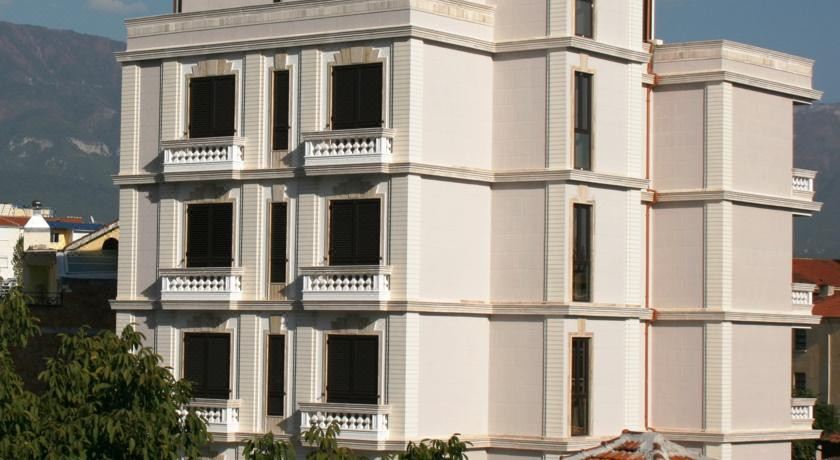 a white building with multiple windows and balconies , giving it a unique architectural design and covering its surface at Oxford Hotel