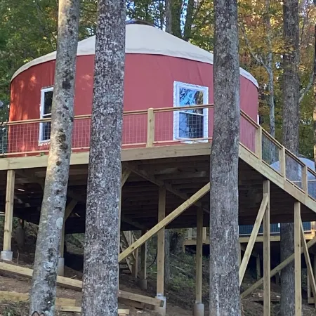 Elevated eclectic yurt with wrap-around porch, hot tub, and mountain view!