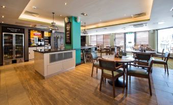 a modern restaurant with wooden flooring , blue and green walls , and various dining tables and chairs at Penrith