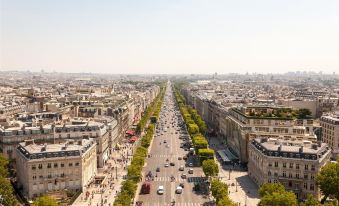 a bustling city street with tall buildings , cars , and pedestrians is seen from an aerial perspective at Hotel Izzy