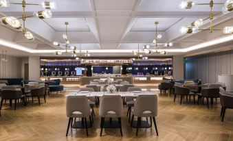 The restaurant features tables and chairs arranged in the center, facing each other at Mercure Shanghai Yu Garden On the Bund