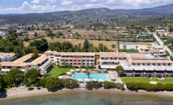 aerial view of a resort with a large swimming pool surrounded by grass , trees , and buildings at Negroponte Resort Eretria