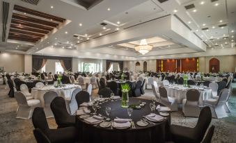 a large banquet hall filled with round tables and chairs , ready for a formal event at Jolie Ville Hotel & Spa Kings Island Luxor