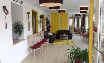 a modern office lobby with yellow walls , black chairs , and a black rug , as well as potted plants and a coffee table at Gasthof Zur Post