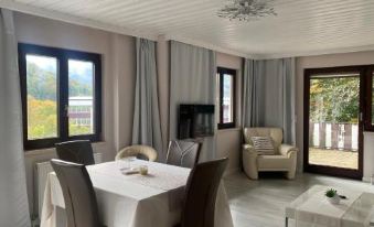 a large white house with a red roof and black shutters is surrounded by greenery at Bad Ischl - Central & Quiet Apartment